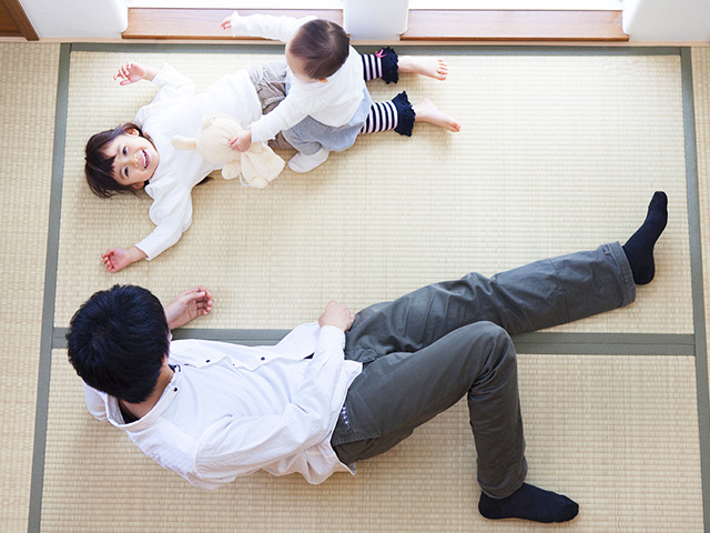 畳に寝転がる家族